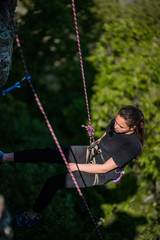 Female rock climber climbs on a rocky wall