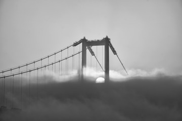 Fototapeta premium Foggy and Misty scene of Bosphorus Bridge. Bridge over the Bosphorus in Istanbul. View from the Asian part of Istanbul. The 15 July Martyrs Bridge in a fog