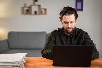 a man works at a laptop, prints, sits at a table, works from home. stay at home challenge