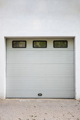 White garage door. Automatic gate with three windows