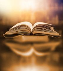 The blurred book that is bewitched with magic, the magic light in the dark, with the bright light shining down as the power to search for knowledge. For research and use as a blurred background