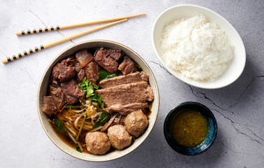 Braised Beef and Meat Ball vegetable Soup with jasmin rice on concrete table flat lay