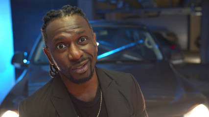 Black bandit in a suit looks at the camera and speaks