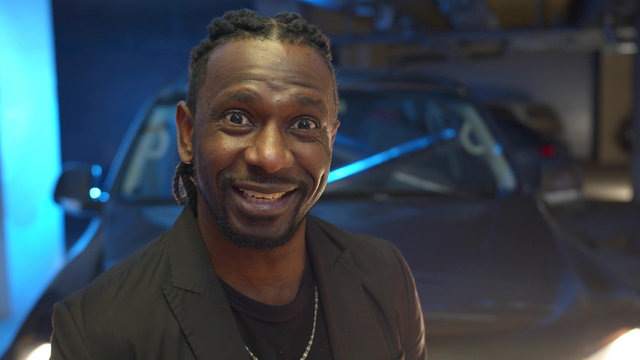 Black thug looks at the camera, smiles and speaks