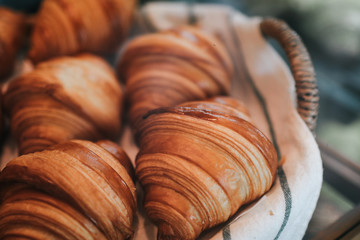Breakfast basket with tasty fresh butter croissants.French bakery variety of sweet buns concept looking yummy.Ruddy crust and vanilla flavor of freshly baked treats. Homemade pastry concept.