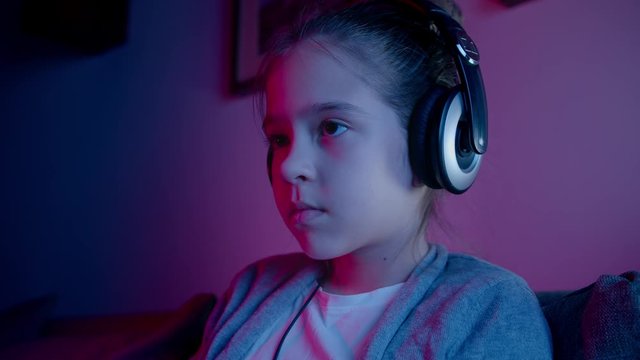 A beautiful girl plays computer games in a neon light. Esports in smartphone