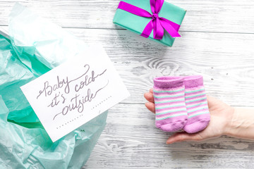 baby's bootees and gift box on wooden background