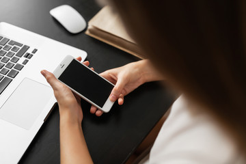 the girl does work from home, looks at information on the phone and checks it against information on the computer during quarantine and pandemic. clouse - up