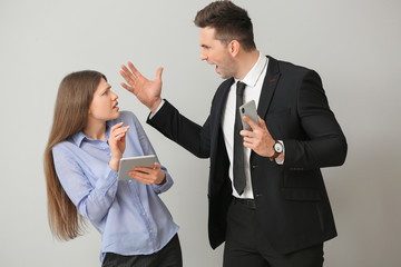 Angry boss scolding his secretary on light background