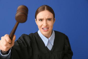 Angry female judge on color background