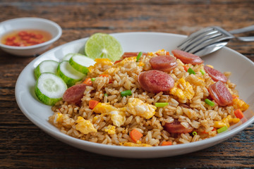 Fried rice with chinese sausage on plate and chili fish sauce.