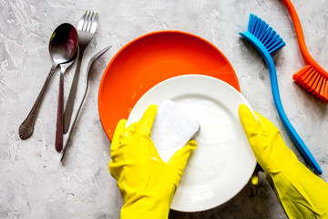 concept of woman washing dishes on gray background top view