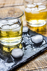 glass of whiskey on wooden background