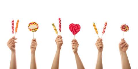 Hands with sweet lollipops on white background