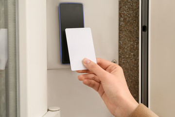 Woman opening door with security card from the outside