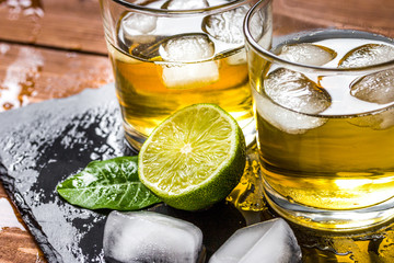 glass of whiskey on wooden background