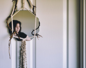 Mirror and a woman's reflection expressing solitude, isolation, worry, concern, anxiety