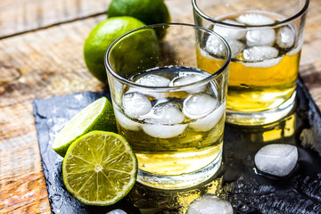 glass of whiskey on wooden background