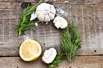 Half sliced lemon with salt and herbs on a dark wooden background. Snack for a drink.Head of garlic.