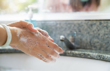 Hygiene concept. Washing hands with soap under the faucet with water on sink to prevent the spread of viruses..