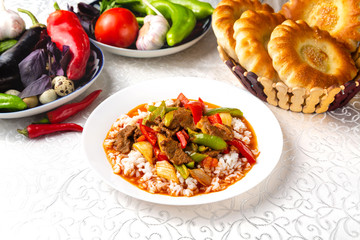 Dish with meat, rice and vegetables. Traditional oriental dish. On a plate on a table in a restaurant.