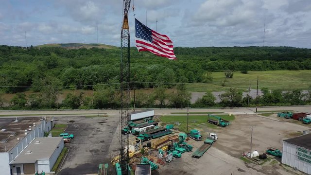 US Flag suspended from a crane in an industrial area, Dayton, Ohio, USA