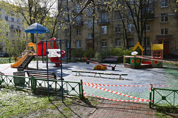 Children playground with snow closed during pandemic of COVID-19
