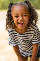 Cute mixed race little girl laughing and smiling.
