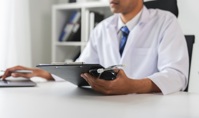 Fototapeta premium Doctor holding the patient report file to assess symptoms on the desk.