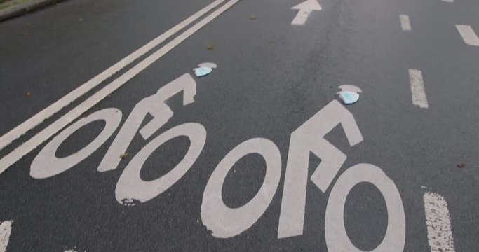 Camera Tilt Up From Road Surface To Empty Park — Painted Bike Symbols Wearing Surgical Masks, Central Park, New York City