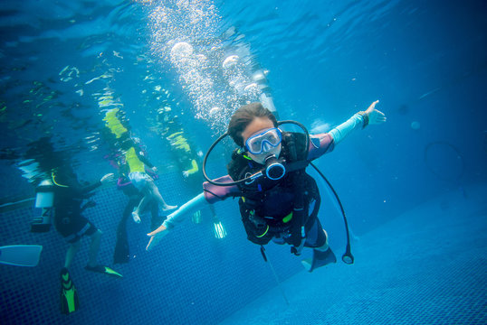 Underwater, A 10 Year Old Boy Diving In A Pool With Fun. This Is Diving For Children.