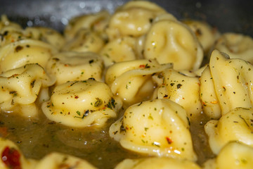 Small dumplings are cooked in a pan with spices. Close up.