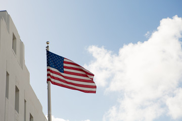 American flag waving against blue sky.