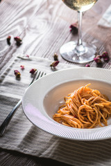 Spaghetti with tomato sauce and white wine on wooden background