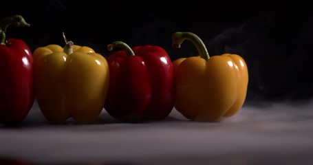 bell pepper lies on a table on a black background in slow motion. Yellow and red pepper - Powered by Adobe