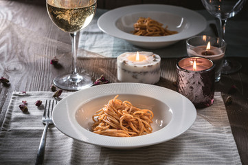 Spaghetti with tomato sauce and white wine on wooden background