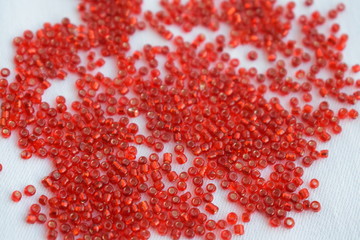 Red beads scattered on a white background.