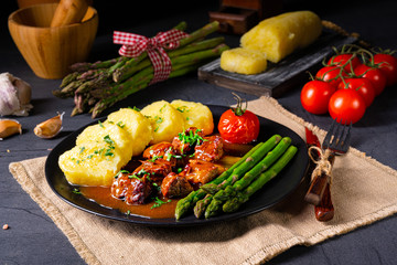 dumplings with beef goulash and green asparagus