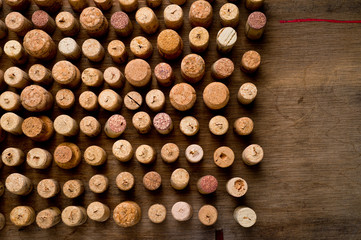 Wine corks of different sizes, standing upright on an old wooden surface. Background for liquor.