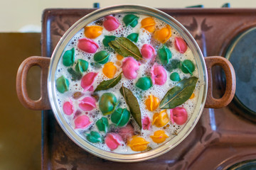 On the stove, a pot with colorful dumplings and Bay leaves.