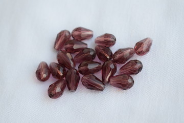 Brown drop beads on a white background.