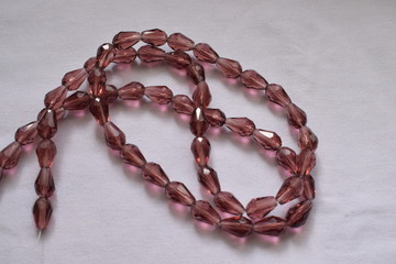 Brown drop beads on a white background.