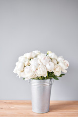 White Odile peonies in a metal vase. Beautiful peony flower for catalog or online store. Floral shop concept . Beautiful fresh cut bouquet. Flowers delivery. Copy space