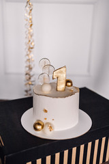Cake of first year birthday with number one on it. Golden cake for child