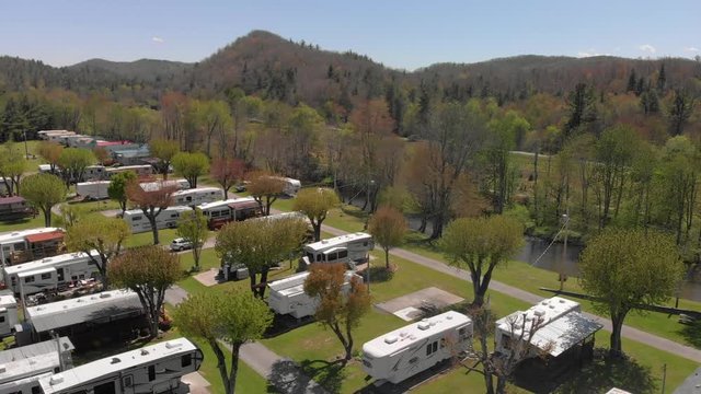 Establishing view of RV campground, homes, river and destination, aerial circle