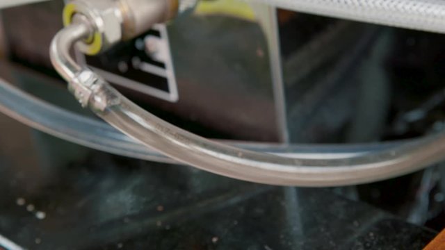 Beer flowing through pipes at the back of a portable draught machine, slowmo HD