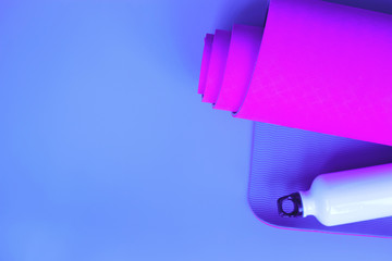 Bright purple yoga mat and bottle of water.