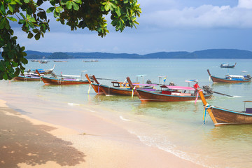 long tail boats on the sandy ocean coast