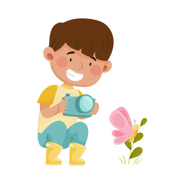 Little Boy Hunkering Down with Camera Taking Photo of Butterfly Sitting on Grass Vector Illustration