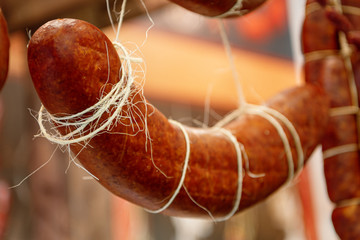 Many smoked sausages hanging on the ropes.